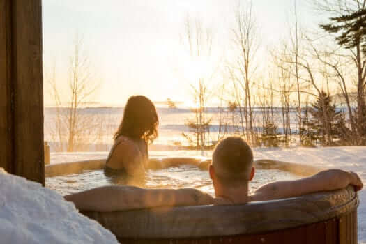Photo of a Couple in a Cabot Shores Hot Tub—the Perfect Place to Relax after Skiing on Cape Breton Island.