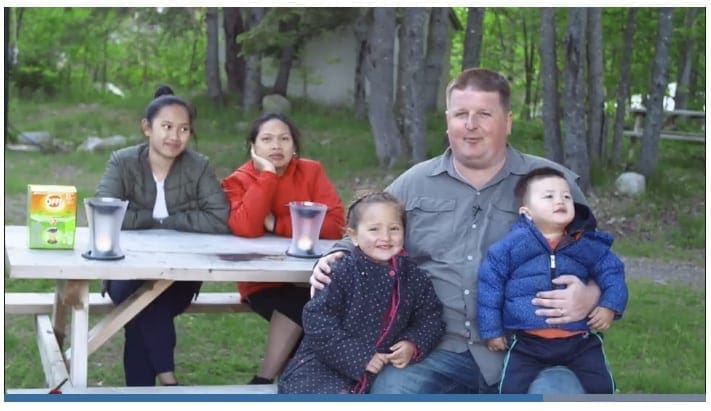 Nathan Coleman sitting with kids and two women on a picnic bench